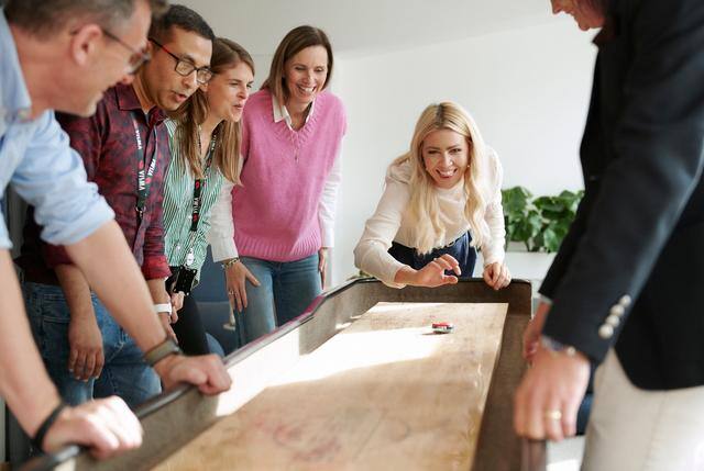 LogBuy Fordelsprogram - Kolleger som spiller shuffleboard på jobb